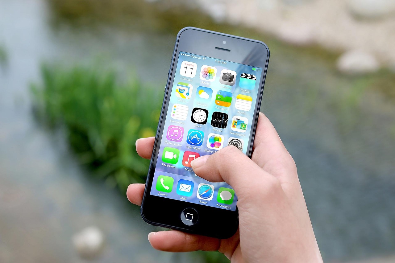 Una mano tiene uno smartphone che mostra la schermata iniziale piena di app, il tipo di dispositivo che Pegasus è progettato per infettare.