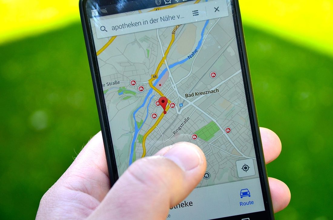 Ein Smartphone zeigt eine Karte und eine Standortmarkierung - Fotos und Apps, die deinen Standort teilen, gehören zu den einfachsten Wegen, über die ein Doxxer herausfindet, wo du wohnst.