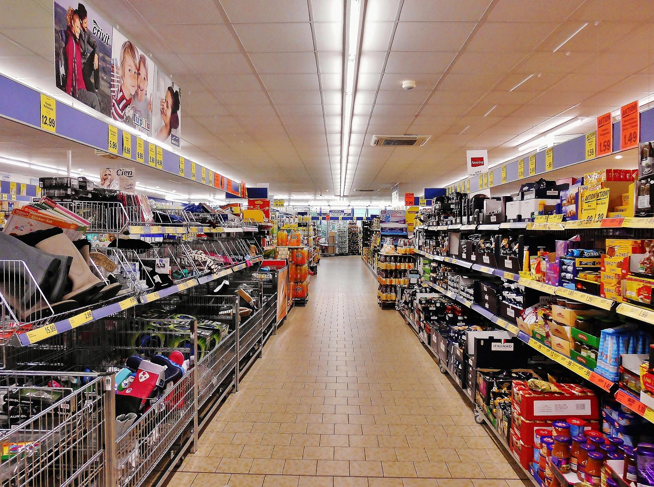 Ein Supermarktgang mit Regalen und gelben Preisschildern